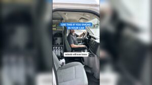 An AI-made detailer character sitting in the driver's seat of a work van with cleaning supplies on the shelves behind him
